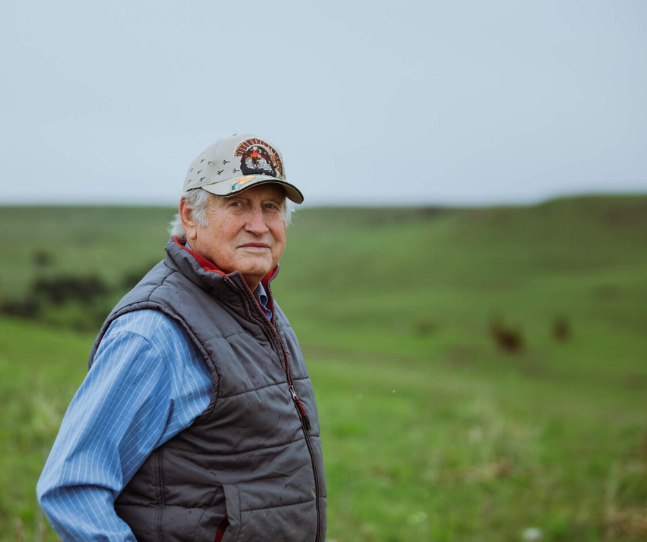 Ron Klataste looking toward the camera standing in grass field.