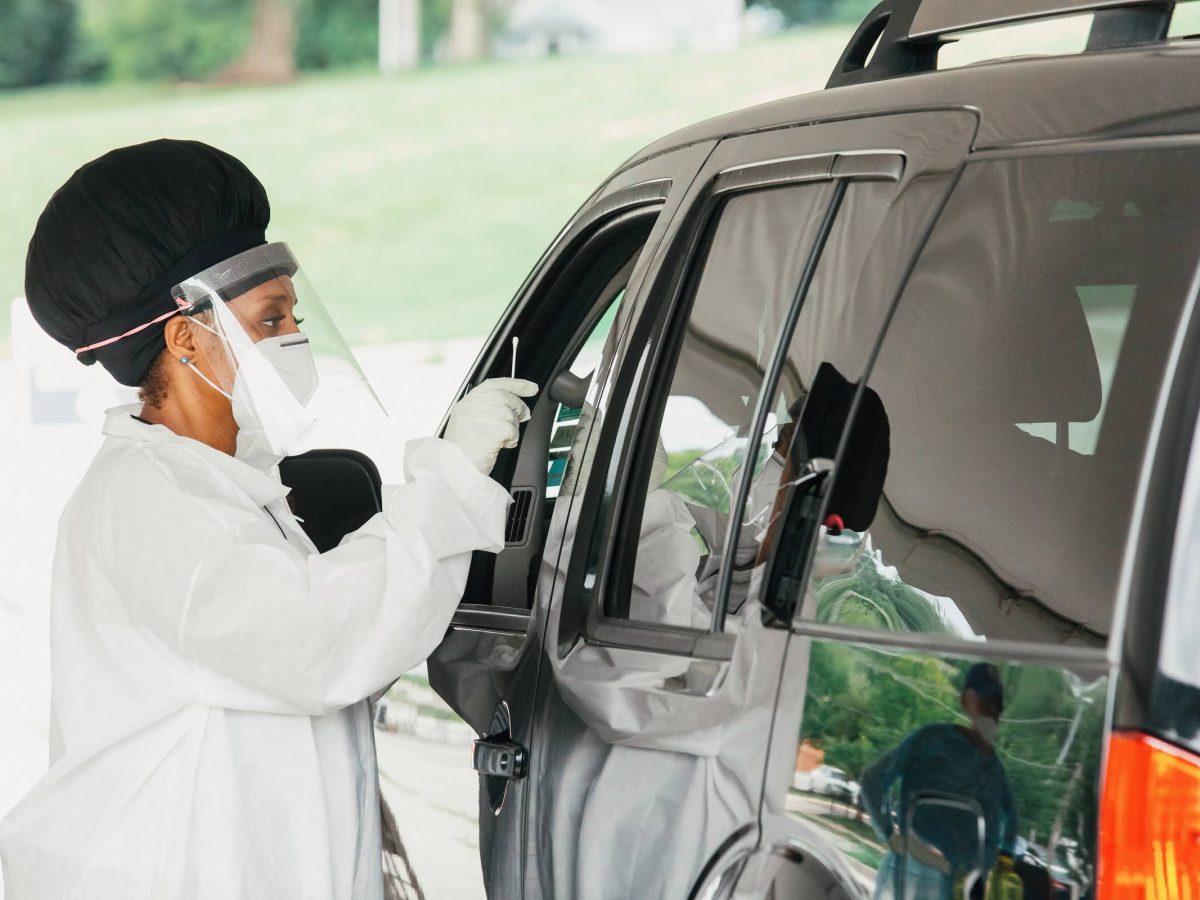 Nurse doing drive up Covid-19 testing with swab