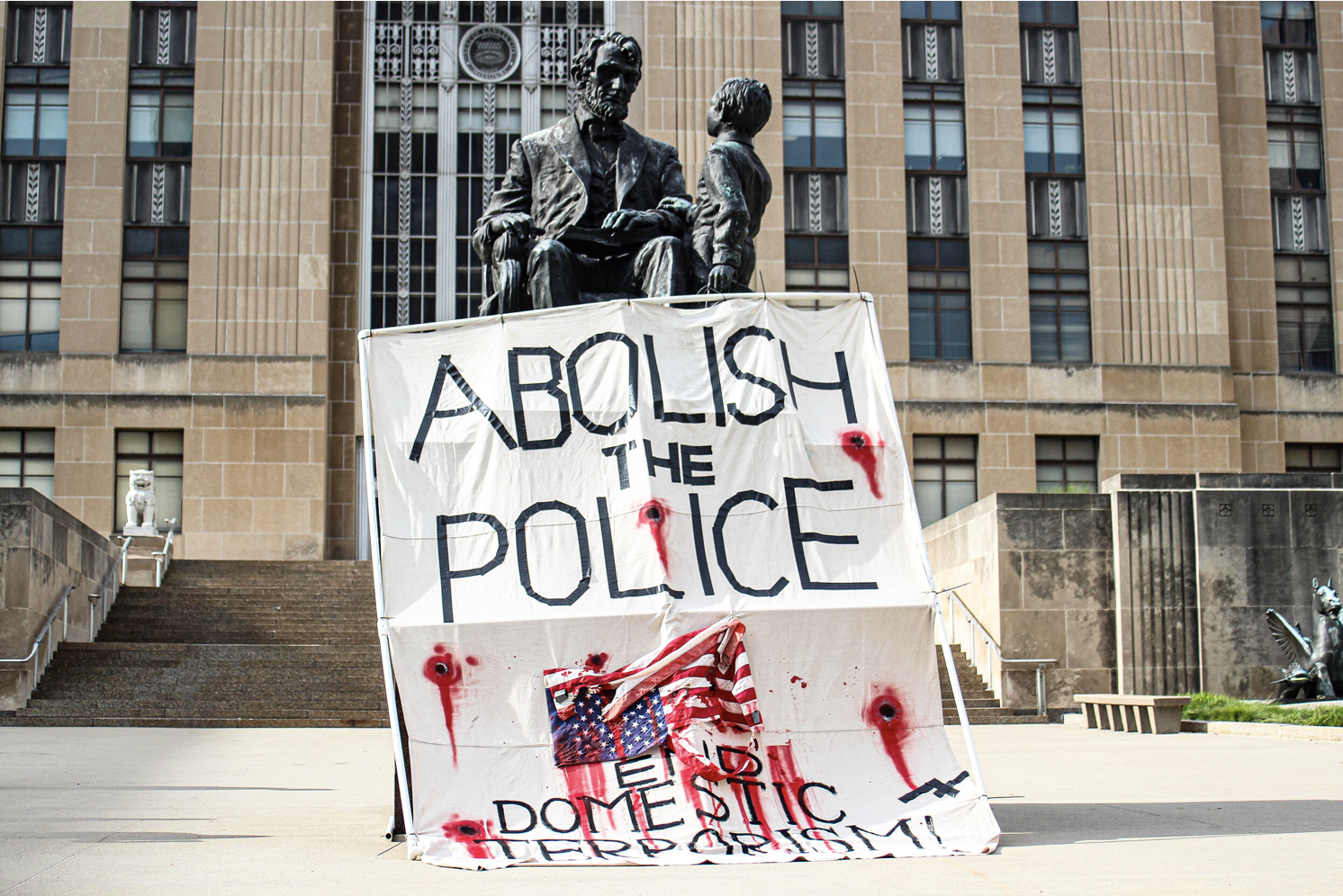 Members of One Struggle KC draped a banner over the statue of Abraham Lincoln during a demonstration outside of city hall on June 8, 2020. (Zachary Linhares/The Beacon)