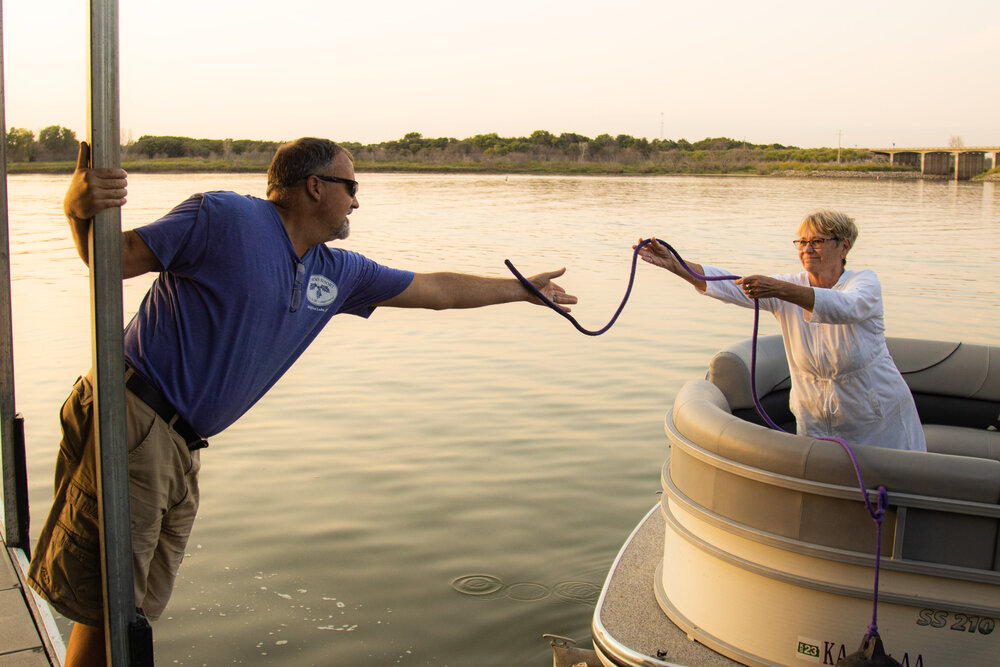 Mike Harris, owner of Acorns Resort at Milford Reservoir, helps a visitor at the lake dock their boat. He’s seen the ways toxic algal blooms can hurt local businesses, like his resort. Zach Bauman/The Beacon