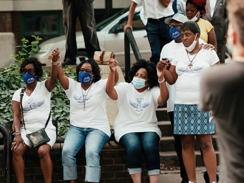 Members of the Stokes family hold hands during a press conference uniting several families who have lost loved ones to police shootings on July 24. Chase Castor/The Beacon