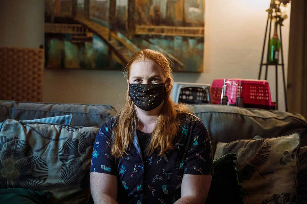 Casye Davidsons sits on a couch in her Hyde Park apartment.