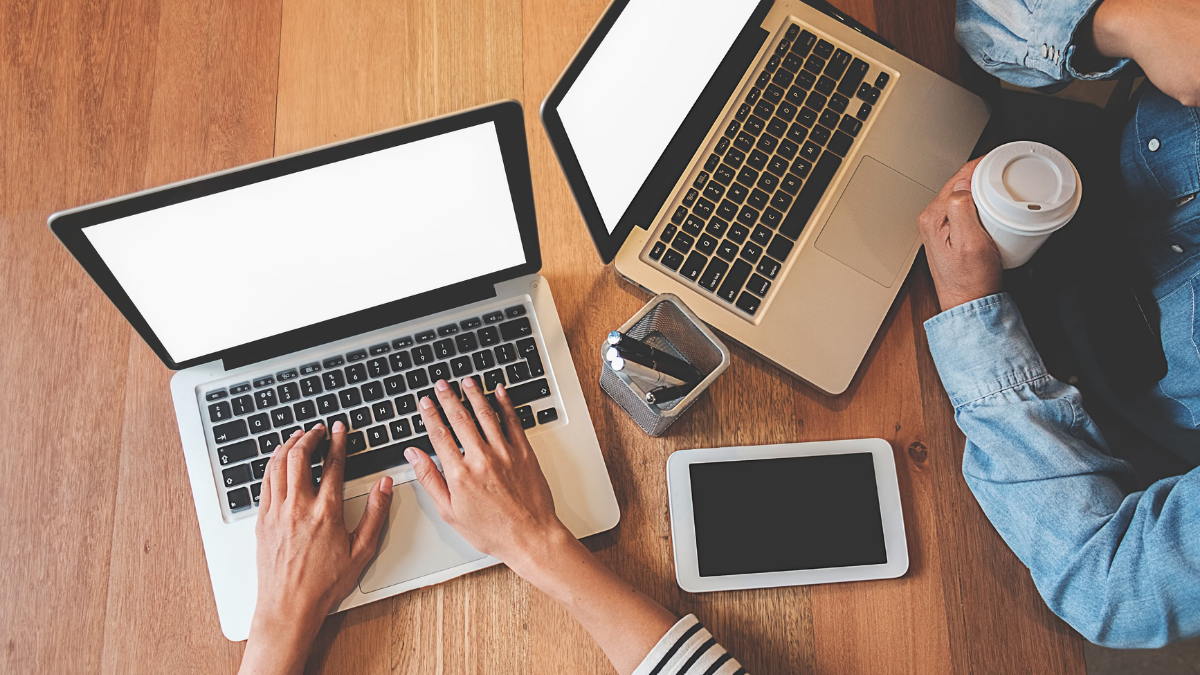 A picture of two people working on laptops.