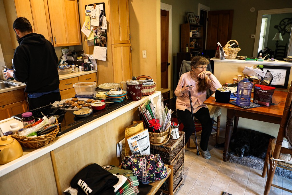 Peggy Bell sits down for a break while Zach continues to prepare their dinner. He has been living with his parent throughout the pandemic.