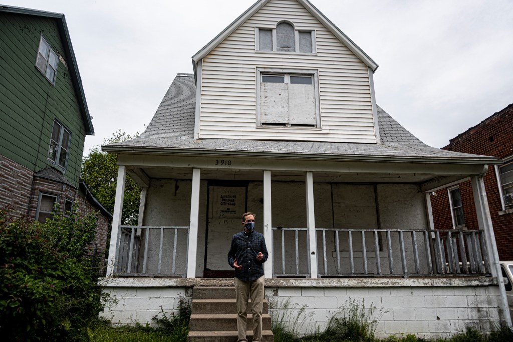 Gregg Lombardi stands in front of a home classified as a dangerous building in the Lykins Neighborhood of Kansas City, Missouri.