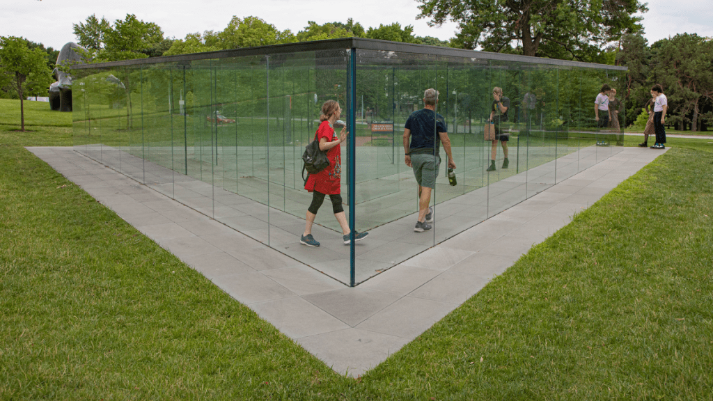 People walk through a clear glass labyrinth in the sculpture garden at the Nelson-Atkins Museum of Art.