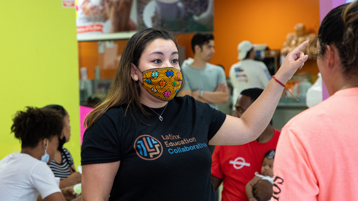 Susana Elizarraraz, VP of educator supports at the Latinx Education Collaborative, speaks to a community member during an education outreach event July 22, 2021, at Frutopia in Kansas City, Missouri. (Zachary Linhares/The Beacon)