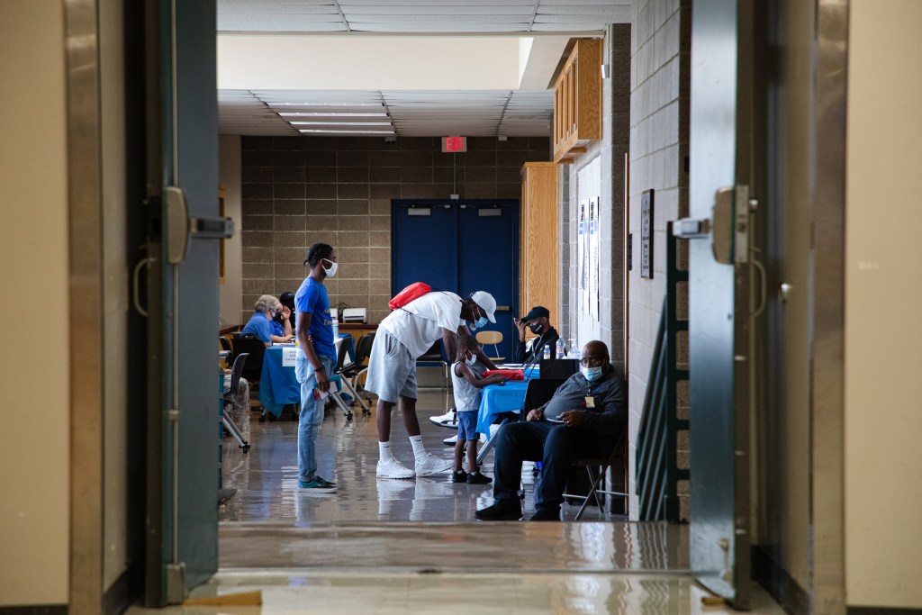 A guardian signs himself and a Kansas City Public Schools student into an enrollment fair held by KCPS on July 28 at Manual Career and Technical Center in Kansas City.