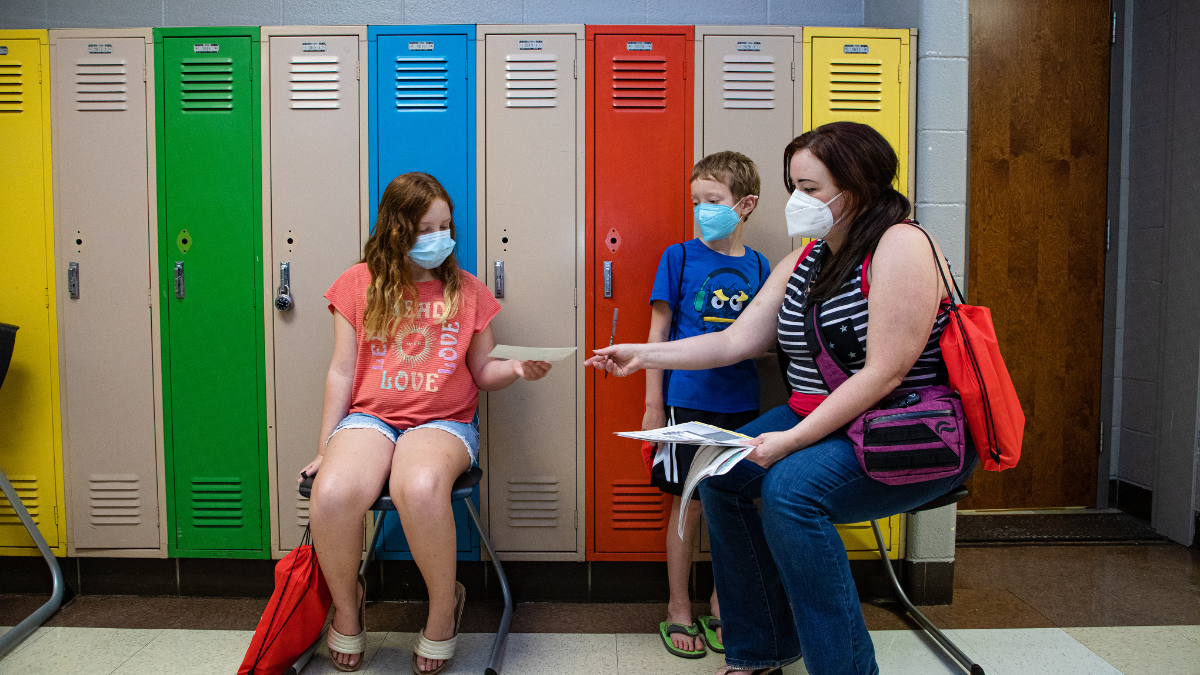 Desiree Martin and her children Hayden, 8, right, and Elliot, 11, are pictured July 28 at an enrollment fair held by Kansas City Public Schools at Manual Career and Technical Center in Kansas City.