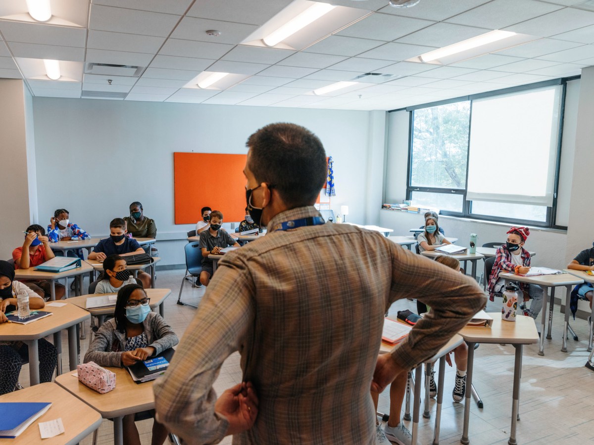 A teacher addresses a class at Lincoln Middle School on the first day of school, Aug. 23, in Kansas City. Like most KC-area school districts, Kansas City Public Schools requires masks.