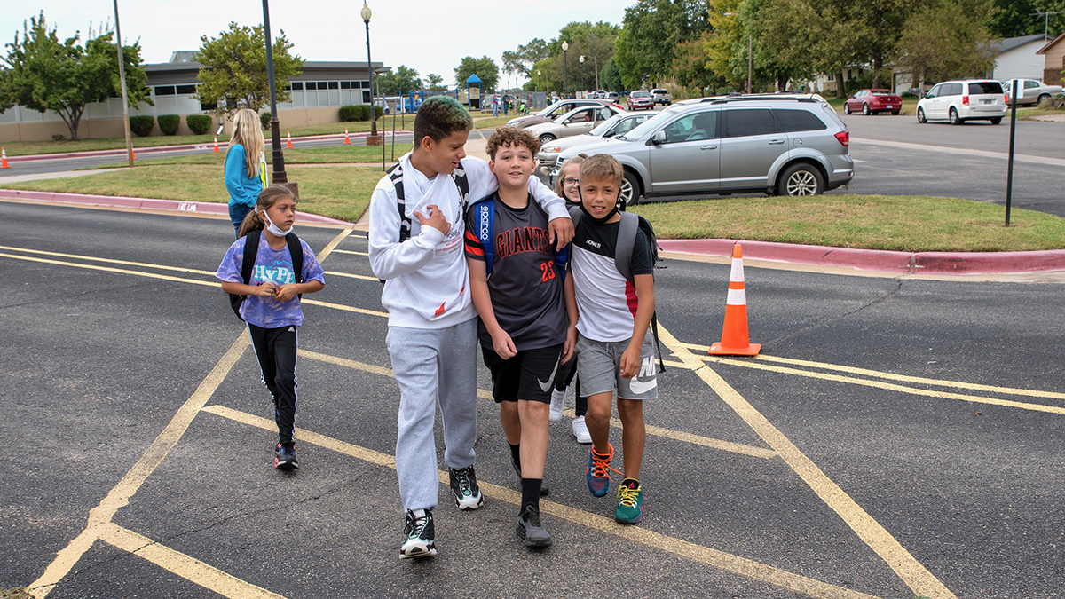 Terrance Brobst wraps his arm around friend Jackson Fasig as they walk out of Nelson Elementary School on Oct. 1. Walking to school together is one of the pair’s favorite parts of their mornings. (Alex Unruh/The Beacon)