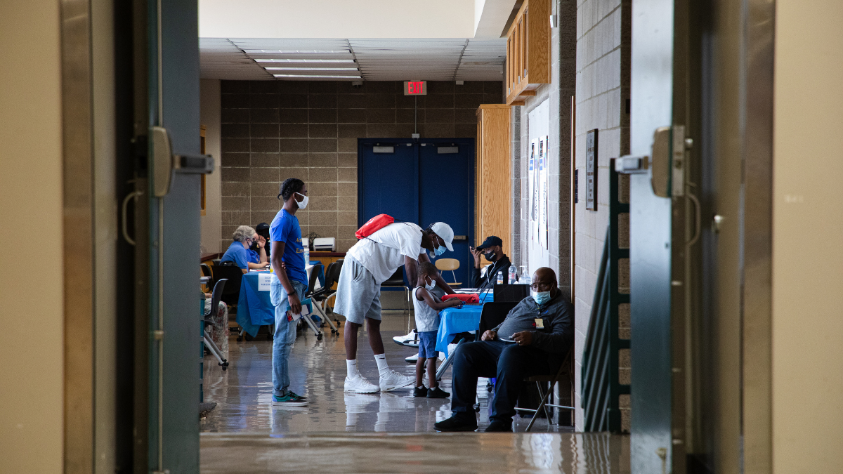 A guardian signs himself and a Kansas City Public Schools student into an enrollment fair held by KCPS on July 28 at Manual Career and Technical Center in Kansas City.