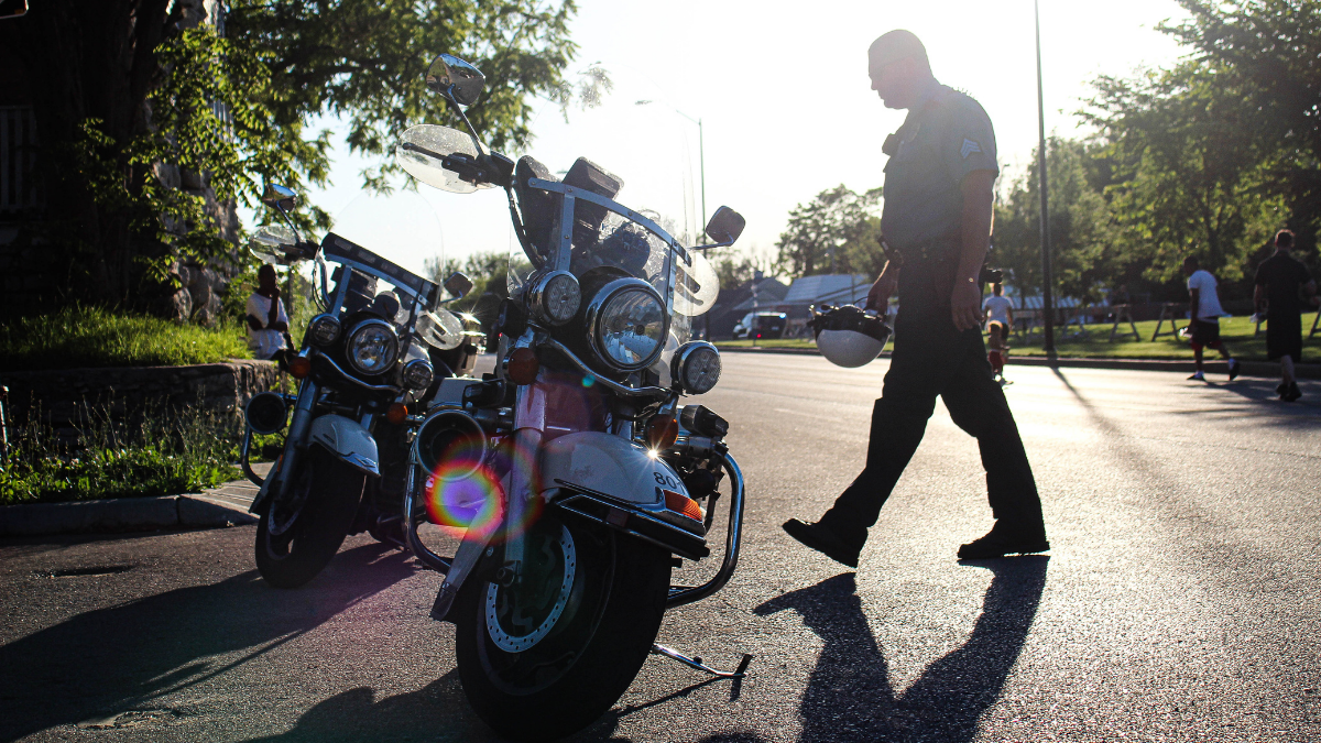 A Kansas City, Missouri, police officer walks back to his motorcycle in front of the East Patrol Division Station. (Zachary Linhares/The Beacon) The Beacon was recently featured in ProPublica's investigative report on Missouri's bid to take control of the St. Louis Police Department.