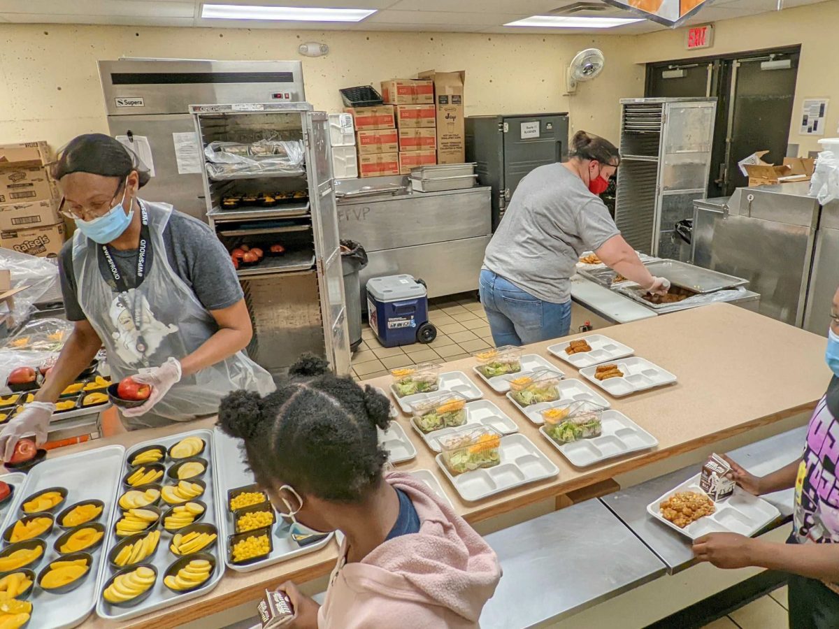 Servers at Buckner Performing Arts Elementary School work students through the lunch line on the last day of school before the holiday break. (Rafael Garcia/The Beacon)