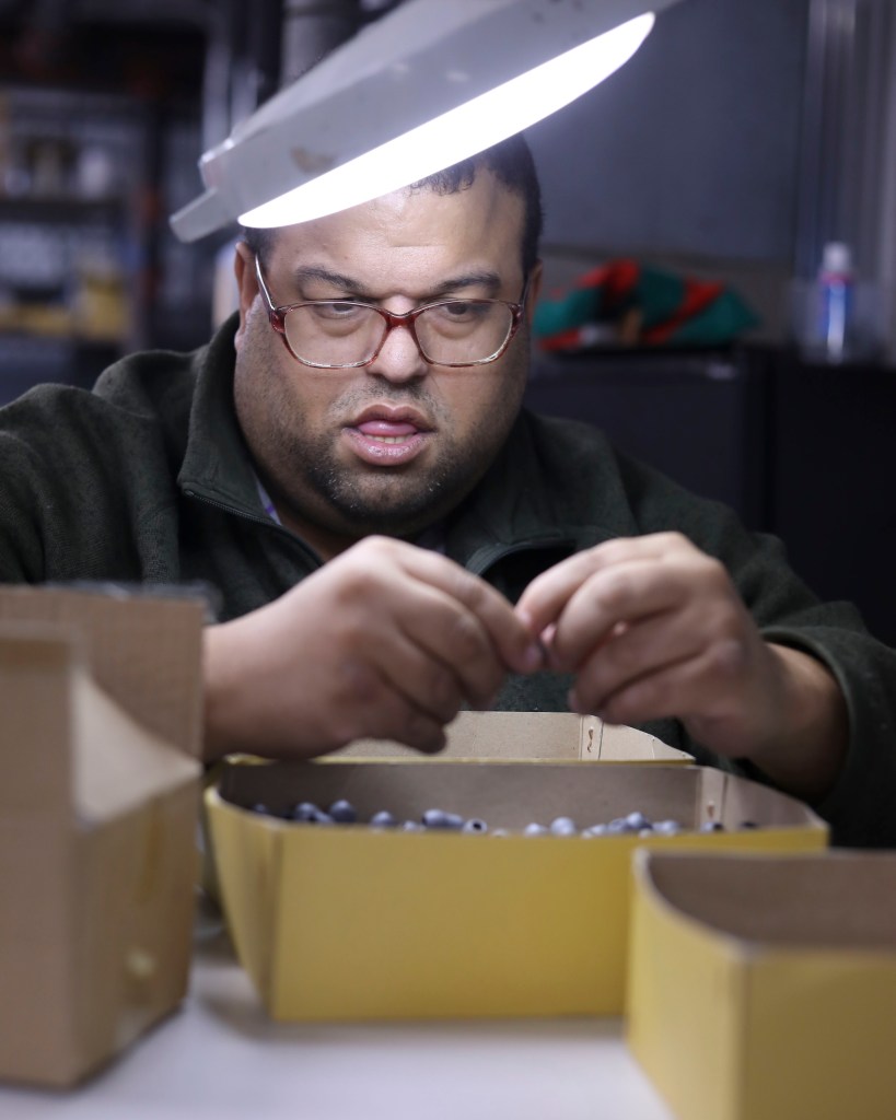 A person sorts through a box of metal parts at a sheltered workshop in Columbia, Missouri. 