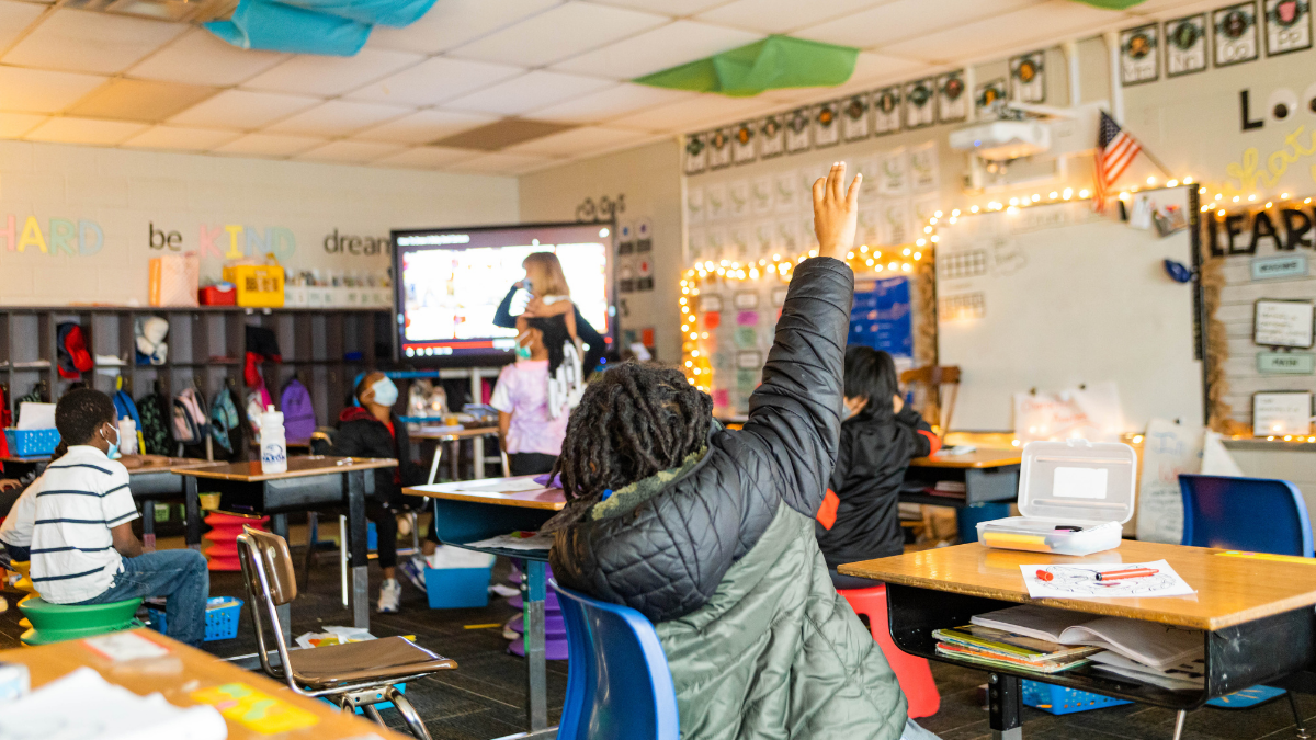 A student raises a hand in a classroom