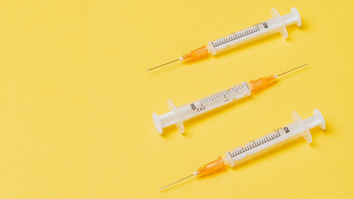 Three syringes are pictured against a yellow background