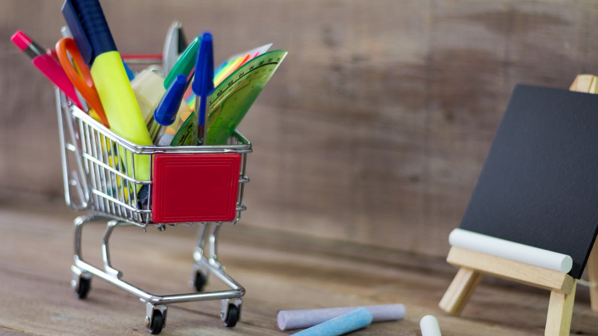 Mini shopping cart filled with school supplies.