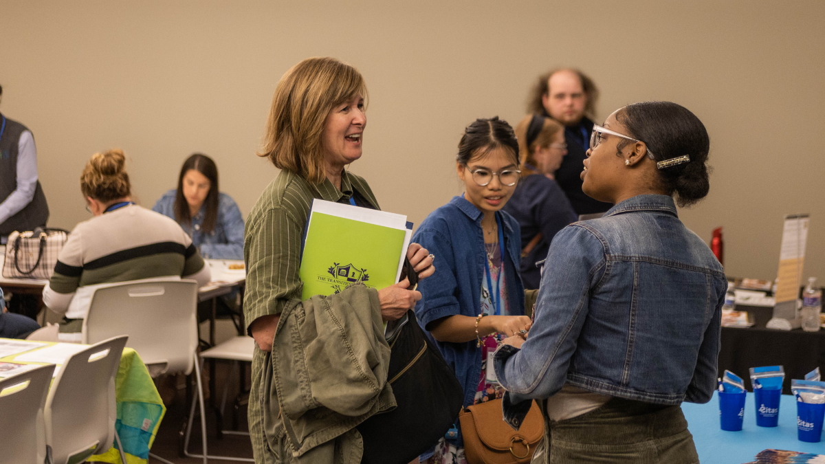 Lori Foulke (left) and Mariel Foulke (center) stop at a table at the Transition Academy's DiversAbility College and Career Fair on April 14 at Metropolitan Community College. Mariel Foulke was looking for additional work opportunities.