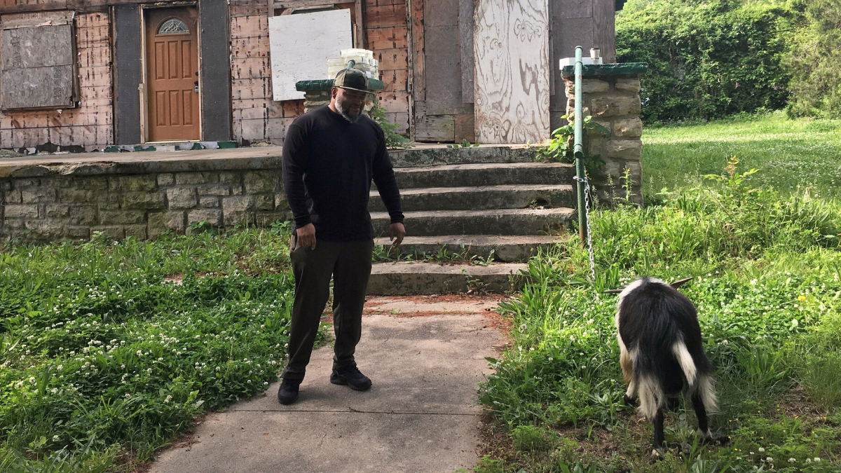 Dre Taylor visiting rehab center standing next to goat.