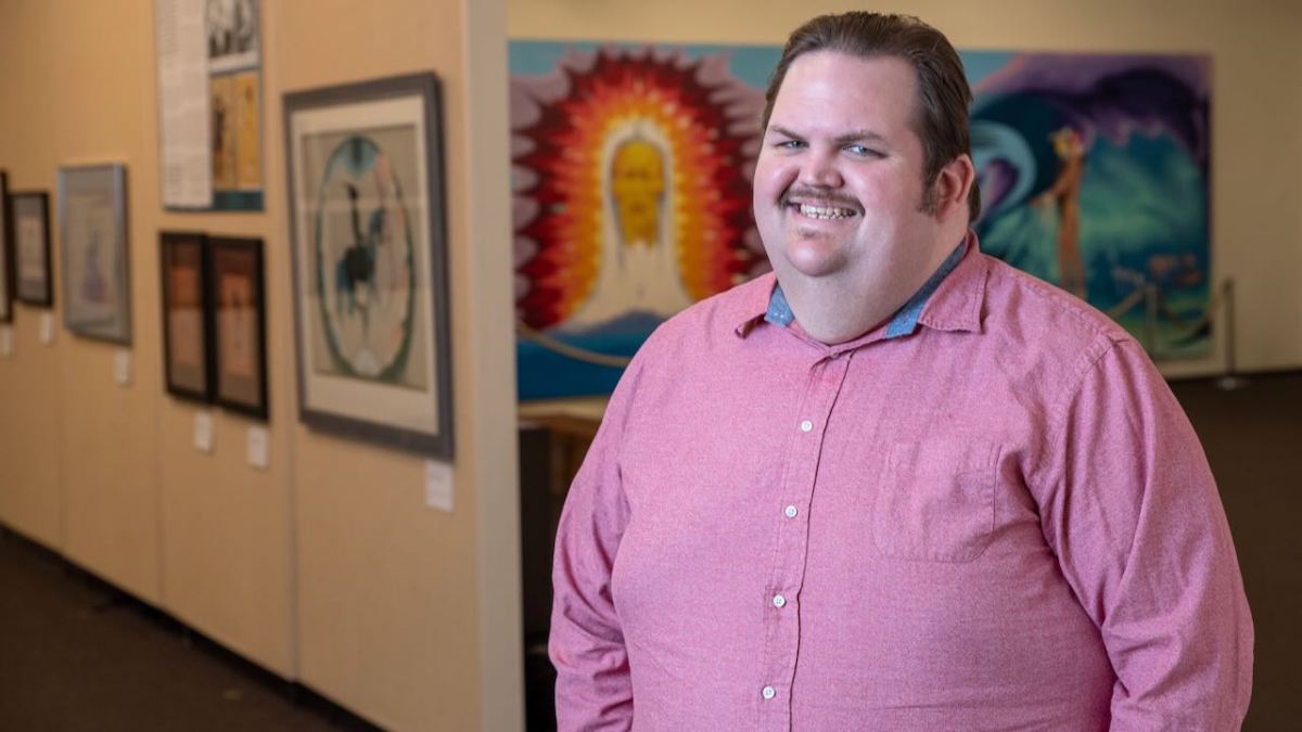 Daniel Pewewardy smiling at camera wearing salmon button up.