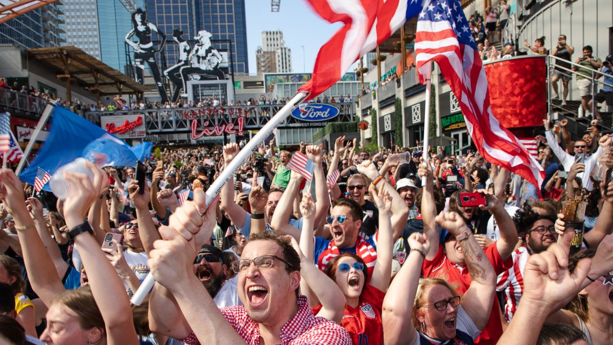 Fans celebrate and wave American flags as the results of the 2026 World Cup host cities are announced.
