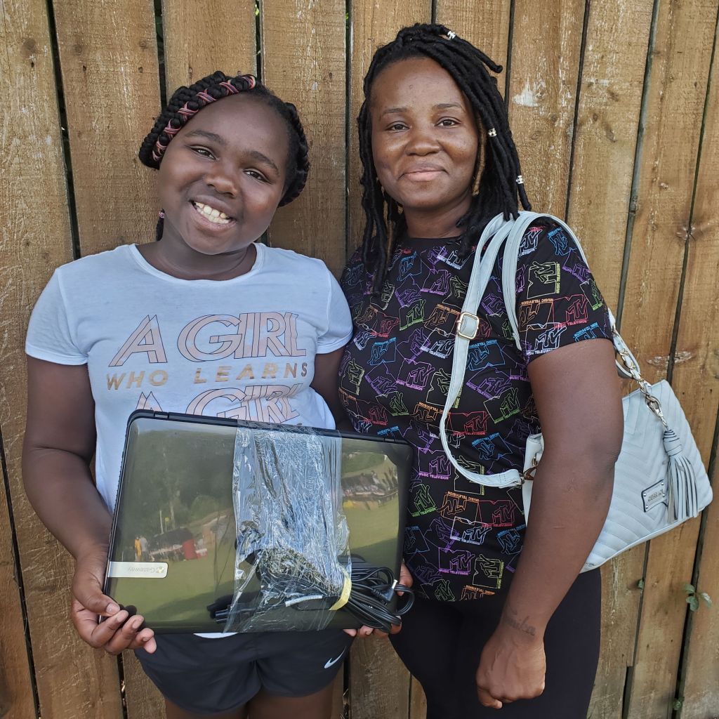 Two customers take a picture with their low-cost device that they received from PCs for People. 