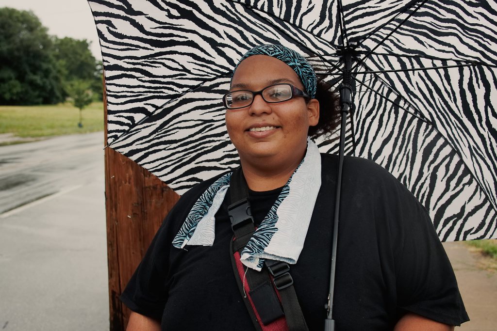 Person waiting for the bus and holding an umbrella..