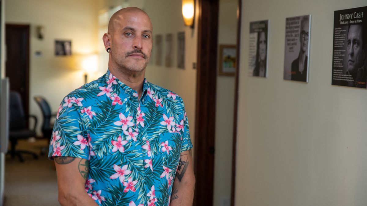 Keith Dockter stands in the hall of Holland Pathways, which has walls that are decorated with celebrity quotes about their addiction recovery.