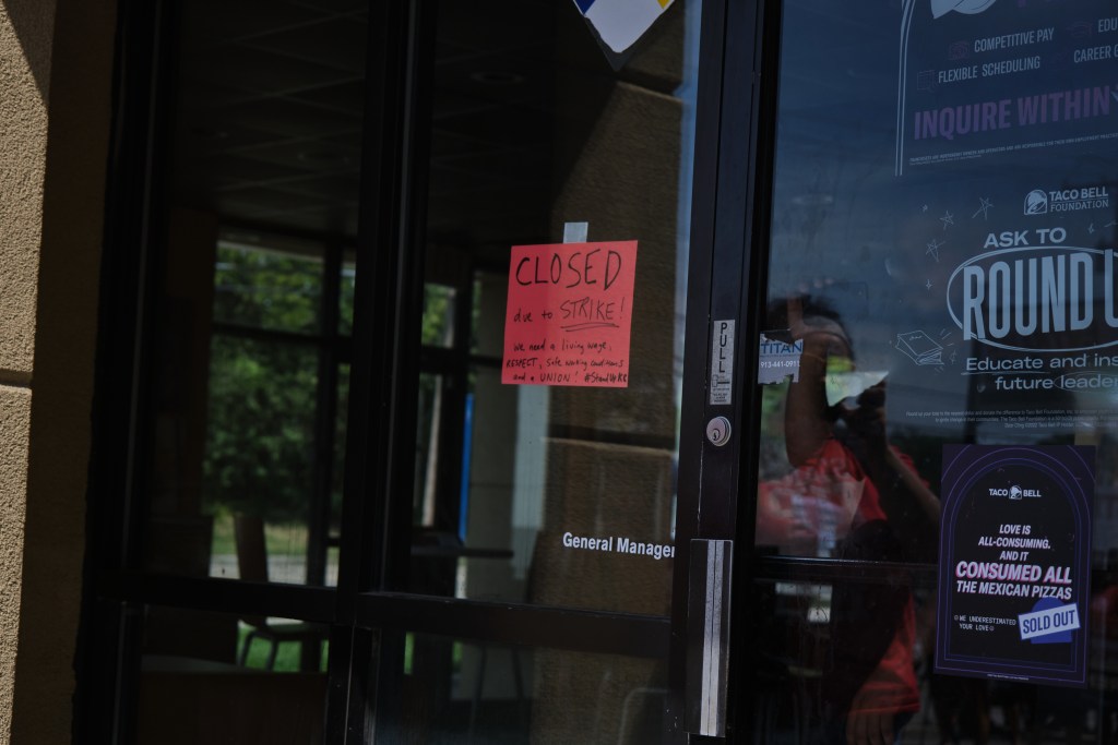 A sign on the door that reads "Closed due to a strike! We need a living wage, respect, safe working conditions, and a union #StandupKC"