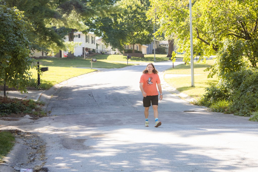 A man walks through the street in his neighborhood
