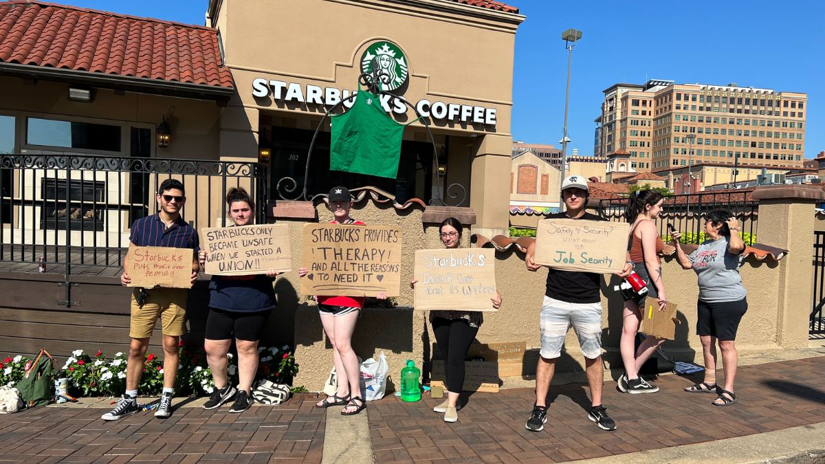 Protestor holding signs in front of Starbucks
