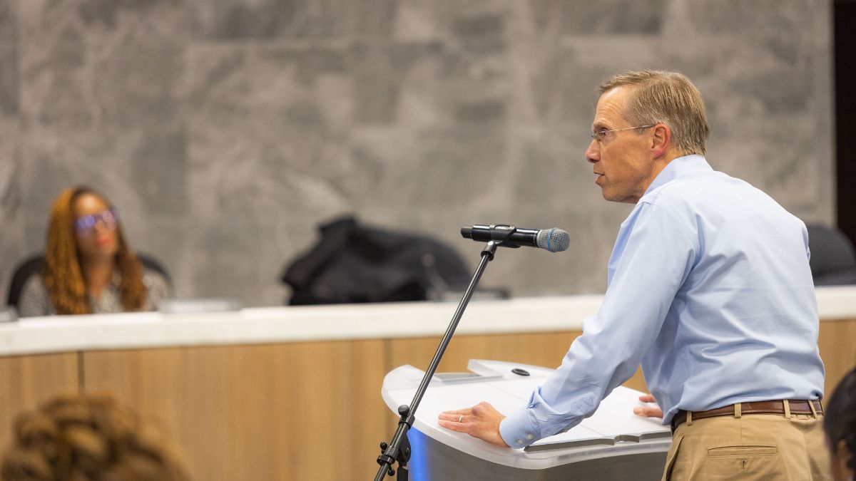 A man speaks at a podium during a Kansas City school board meeting