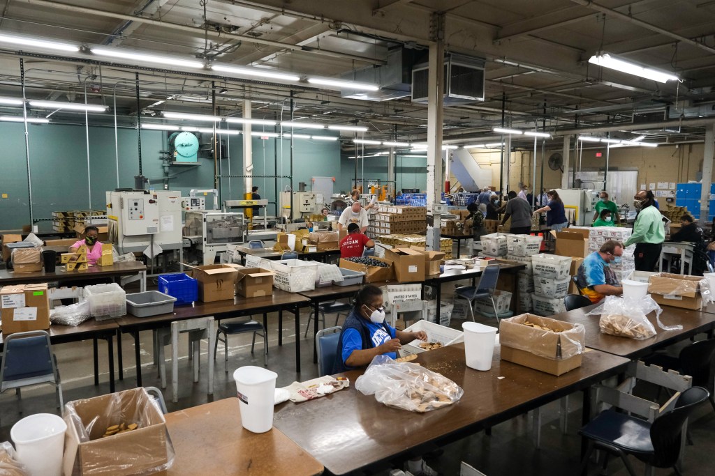 Workers sort, count and package dog treats at Project CU.