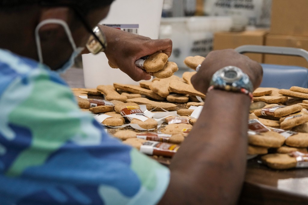 Workers sort, count and package dog treats at Project CU.