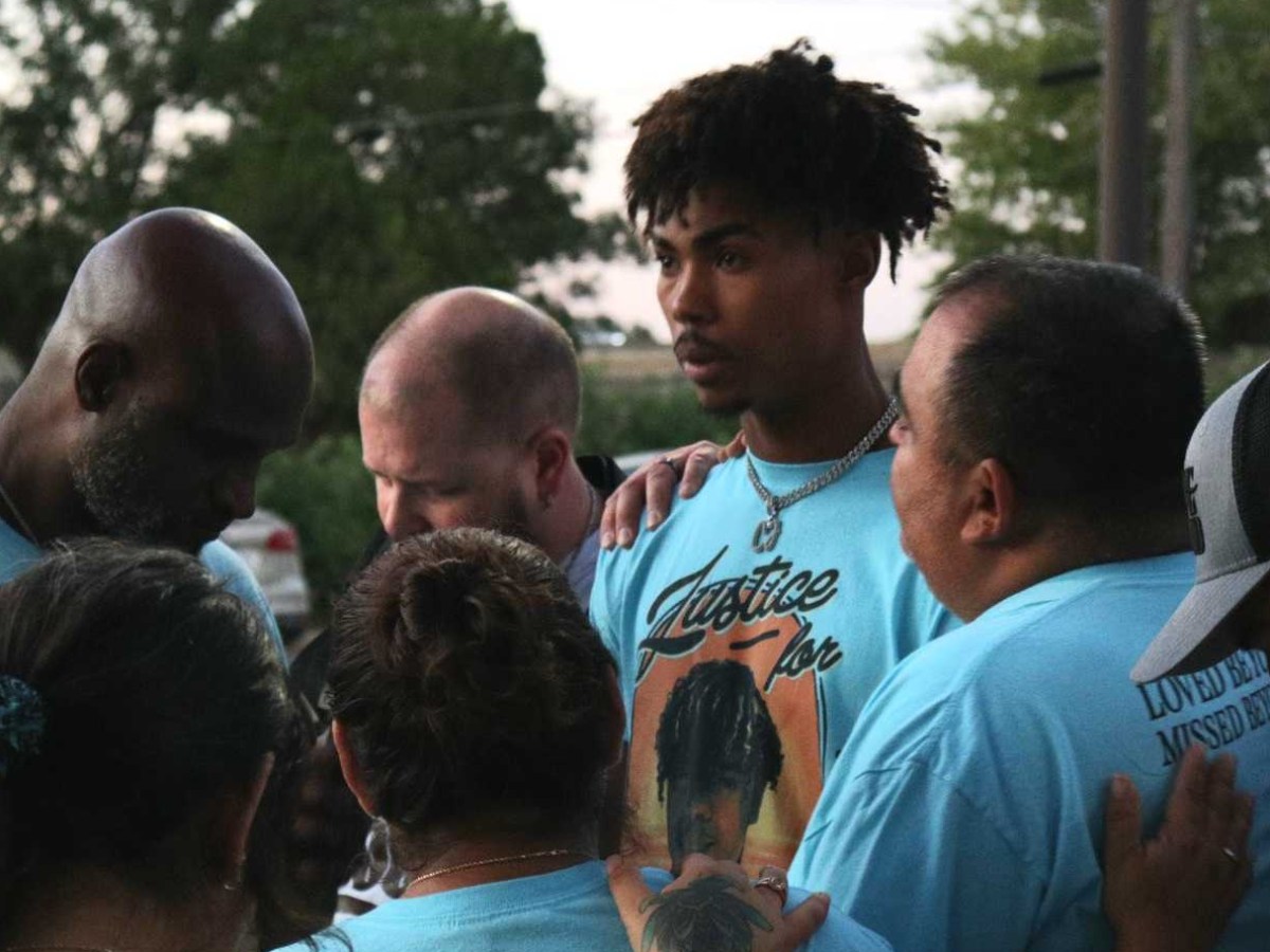 Mark Teetz in the middle of a crowd. All wear shirts with Cedric Lofton on them.
