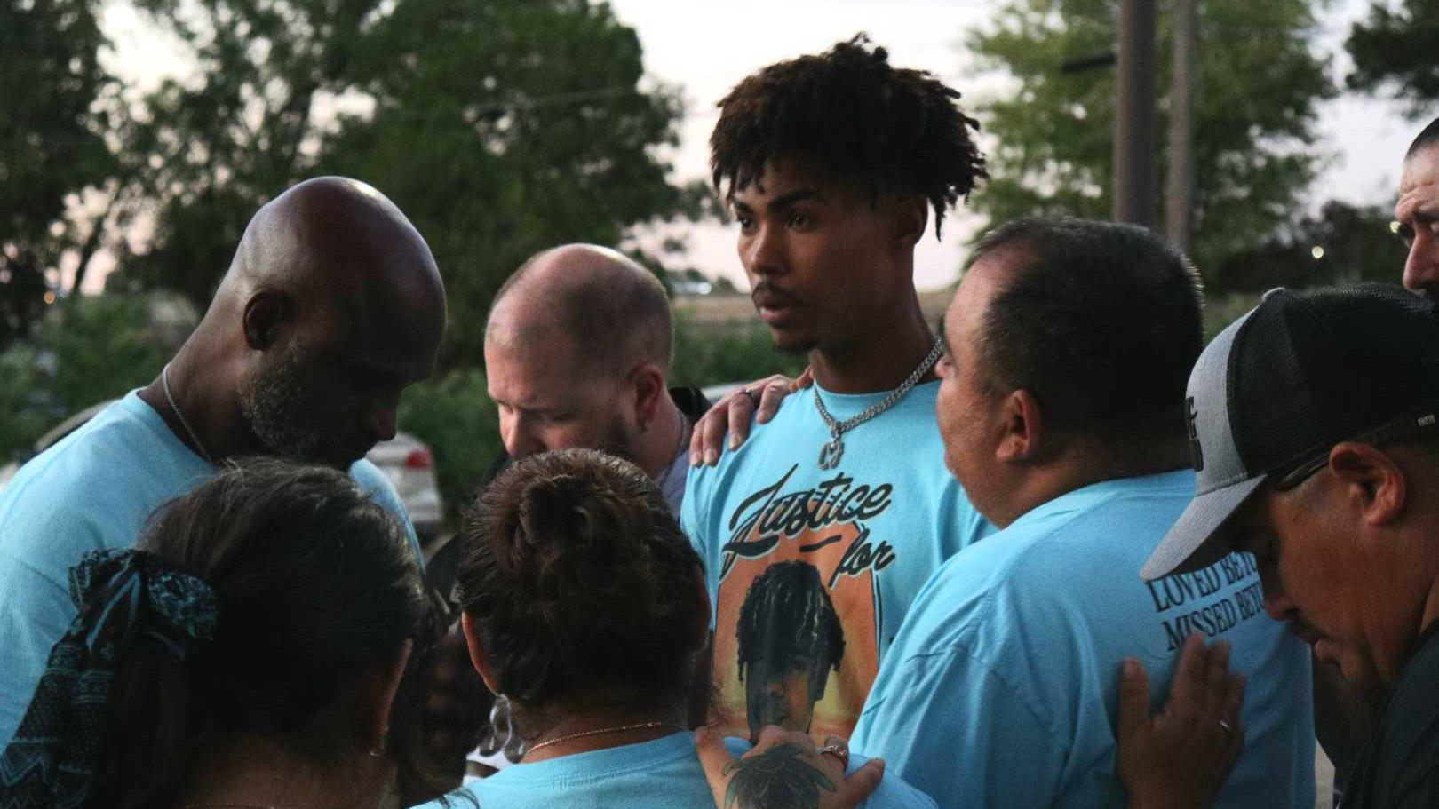 Mark Teetz in the middle of a crowd. All wear shirts with Cedric Lofton on them.
