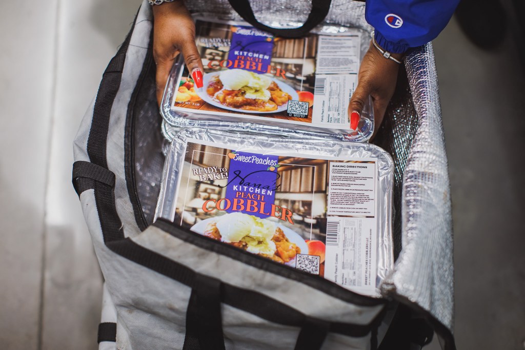 Denisha Jones takes the pre-packaged Sweet Peaches Cobblers out of the case