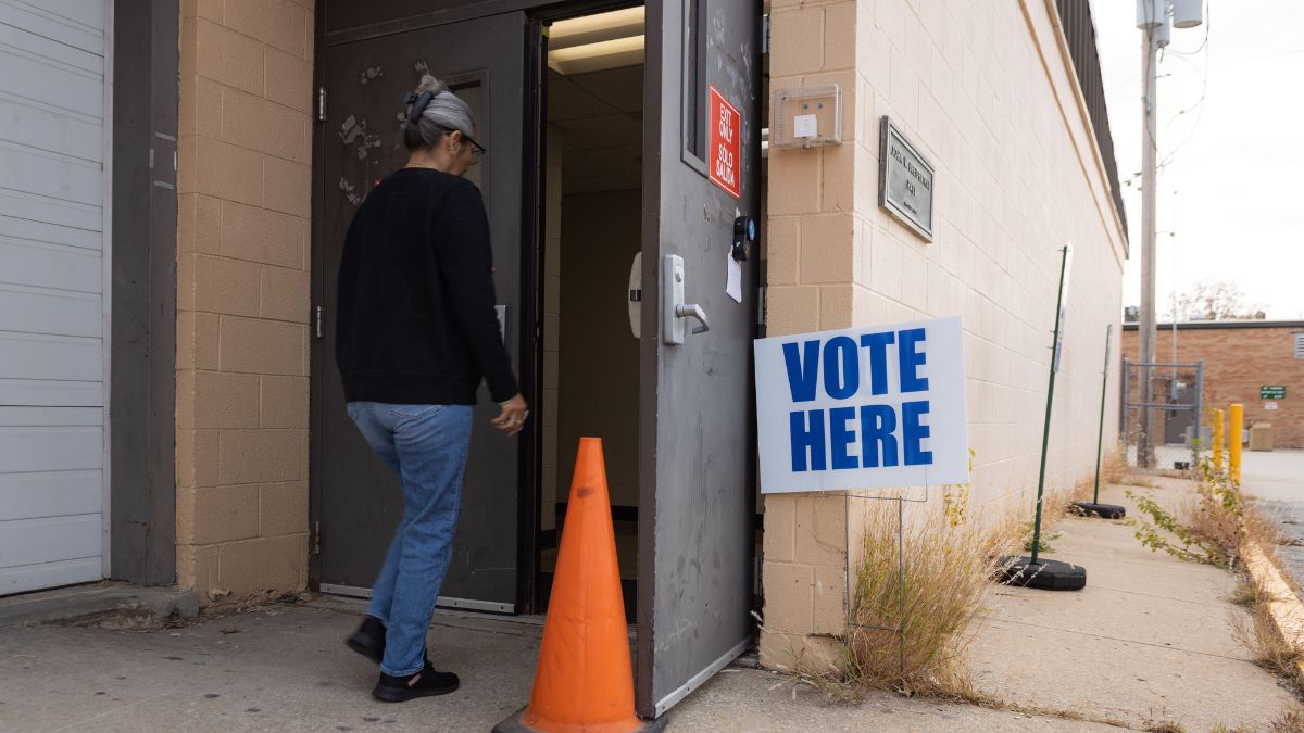 A voter enters a polling location at KU Medical Center on Nov. 8. A sign that says "Vote here" is to the right of the door, held open by a traffic cone.