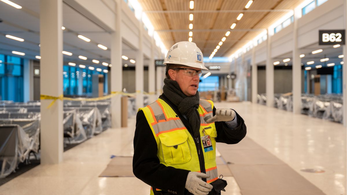 Justin Meyer, deputy director of the Kansas City Aviation Department, directs a tour of the new terminal while also wearing his protective gear and a hard hat.