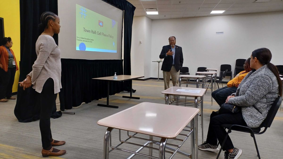 Two people present a powerpoint to a group at DeLaSalle Education Center
