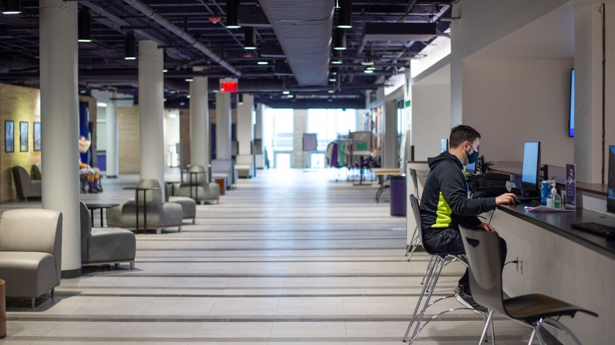 A student studies for finals at a desk.