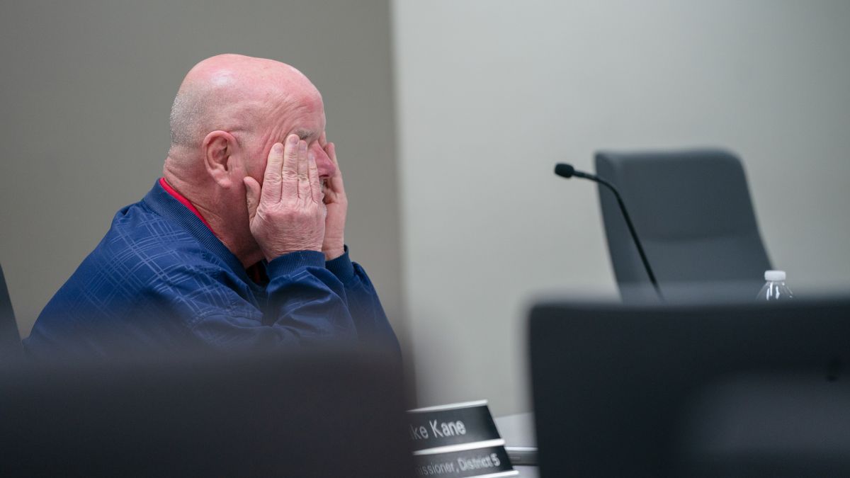 Commissioner Mike Kane rubs his eyes while seated at a committee meeting.