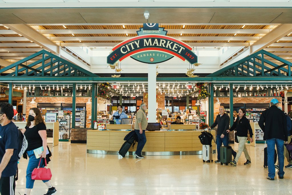 The shopping node in Concourse B, decorated to look like City Market. A large sign says, "Historic City Market," with the exposed brick walls and green metal posts.