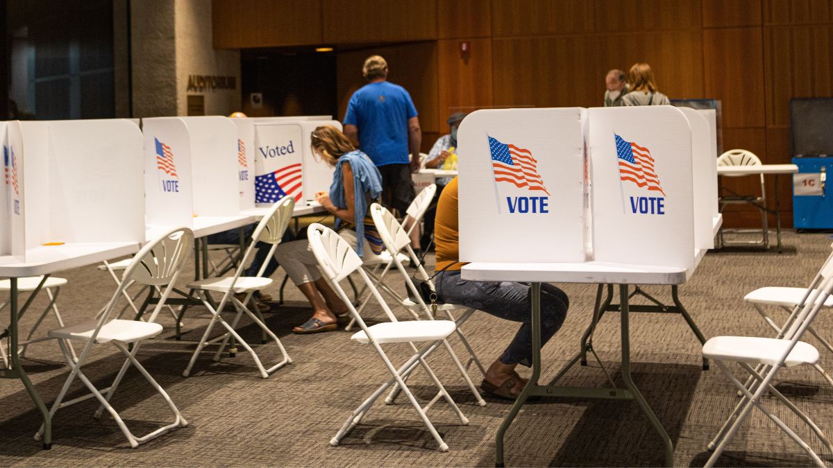 Voters fill out ballots at a poll site inside.