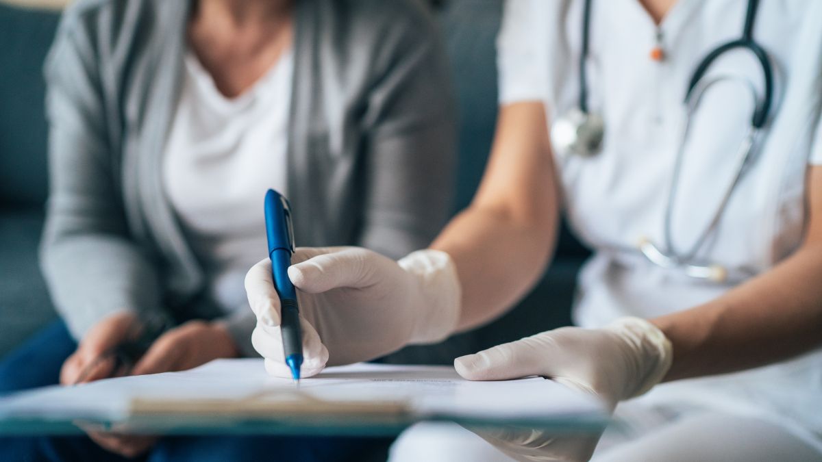 In a file photo, a nurse shows paperwork to a patient in a doctor's office. A Texas study found that those who utilized pandemic-era postpartum Medicaid expansion used twice as many postpartum services compared to those who didn’t.