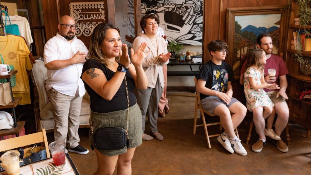 Attendees react during a campaign event for KCPS school board candidate Robert Sagastume.