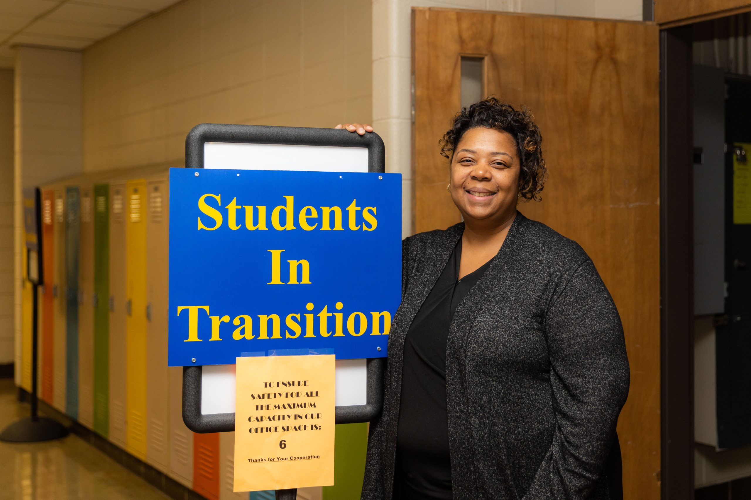 Melissa Douglas near a Students in Transition sign. The office works to remove barriers for homeless students.