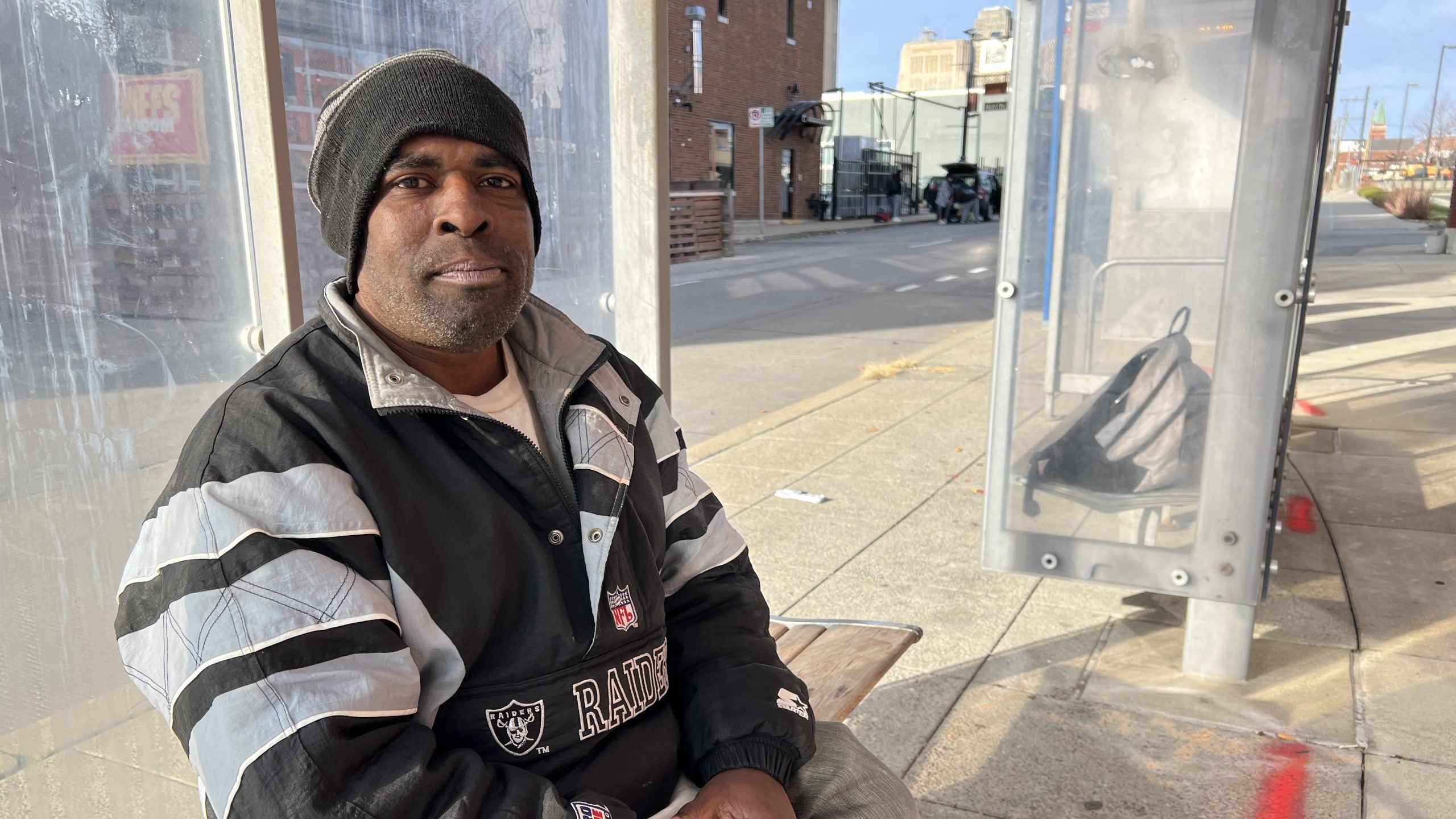 A man sitting at a bus stop.