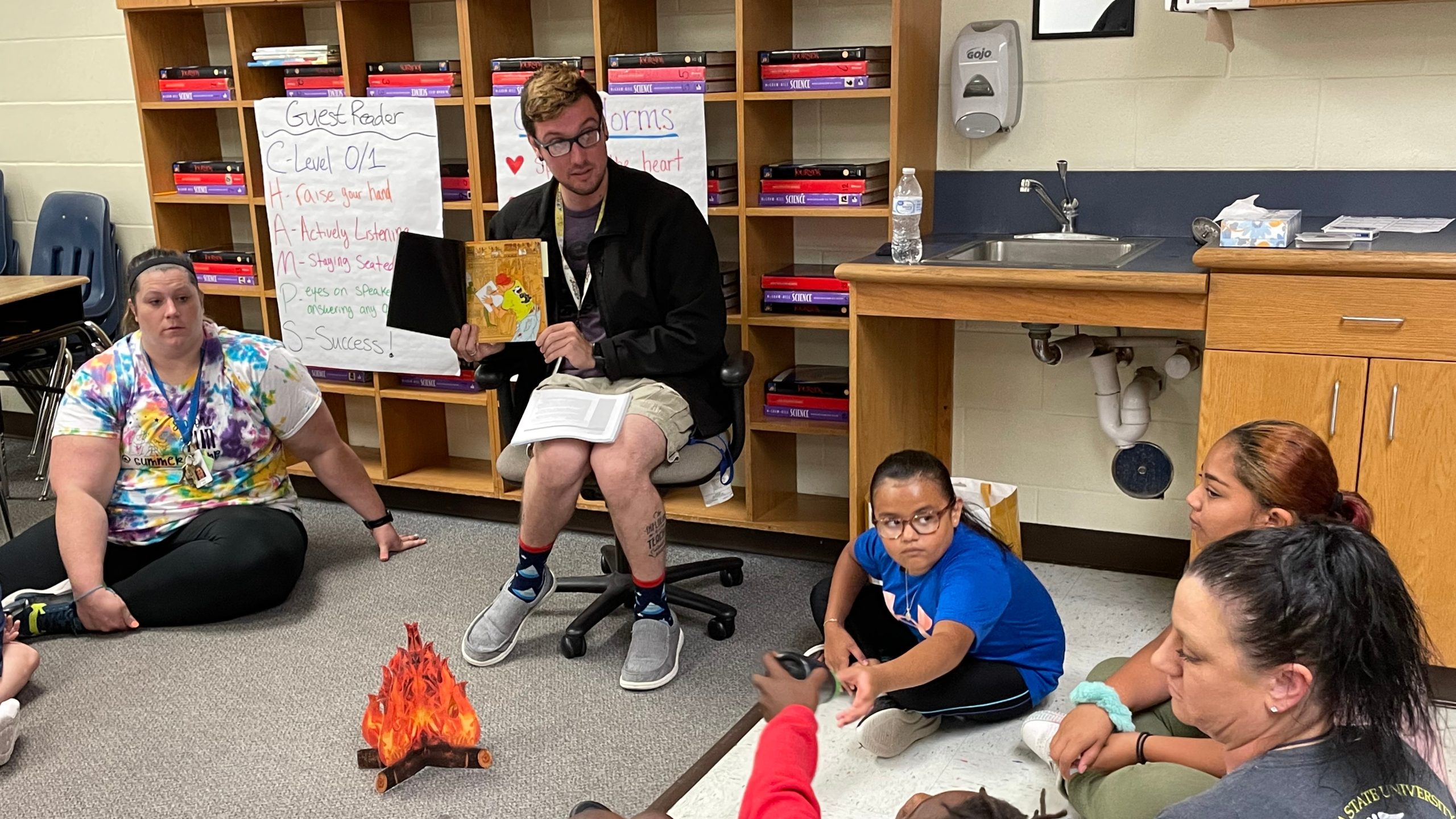 A teacher reads a book to a class.